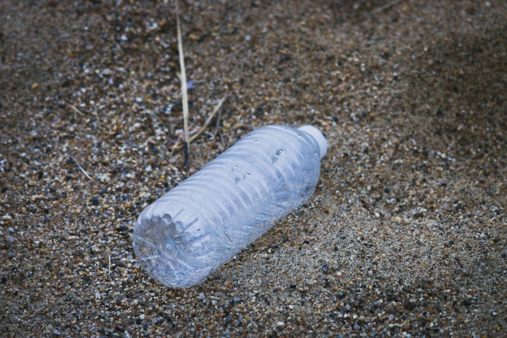 Une bouteille d’eau abandonnée sur une plage, symbole de la pollution plastique en France.