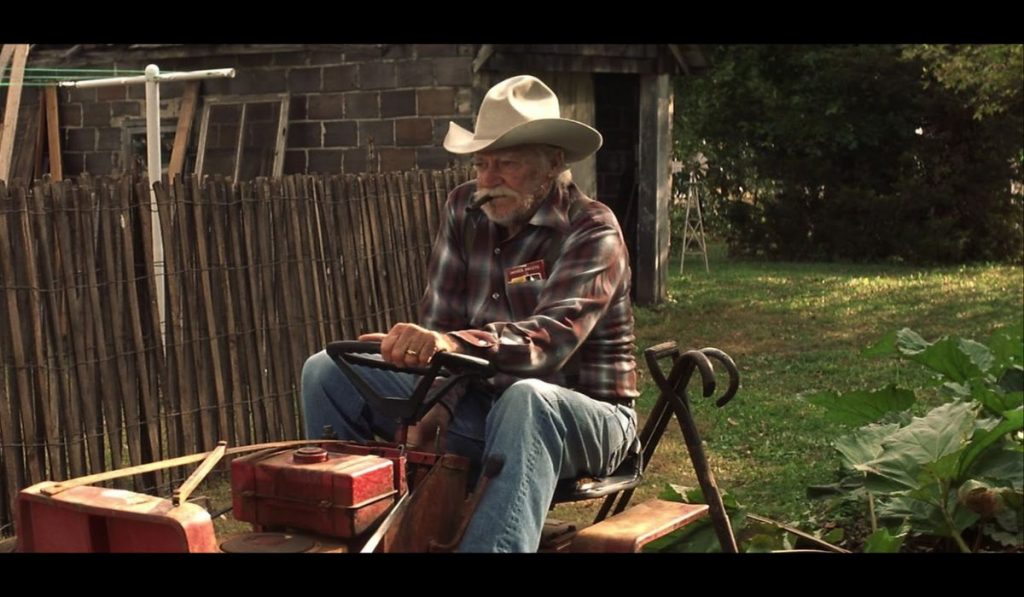 Alvin sur sa tondeuse avec un chapeau de cow-boy