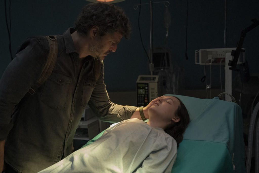 Joel auprès de Ellie sur un lit médical